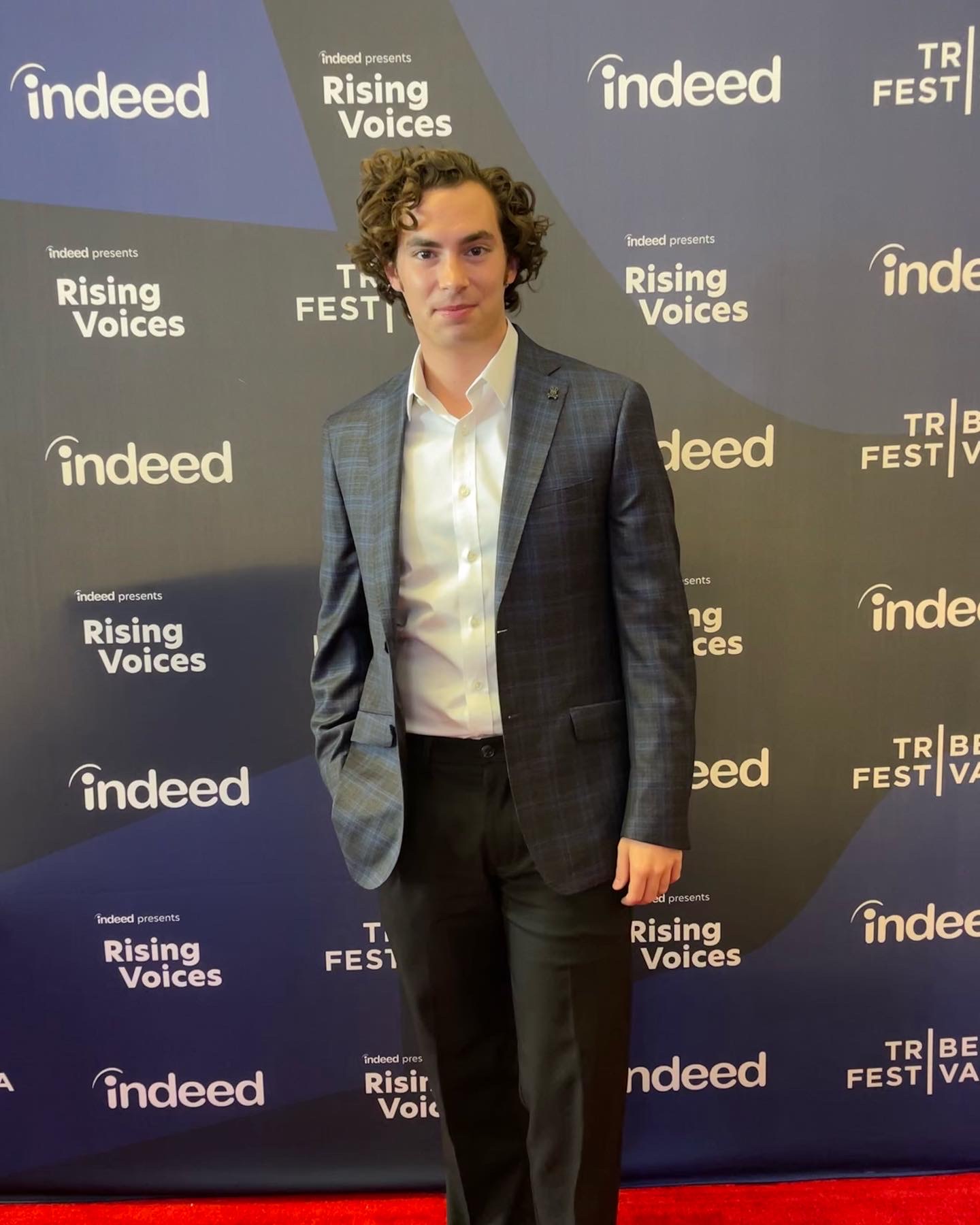 Neil in a blue blazer on a Tribeca Festival "Rising Voices" red carpet